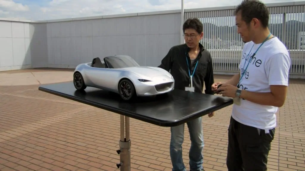 designers look over a model of the ND Mazda MX-5
